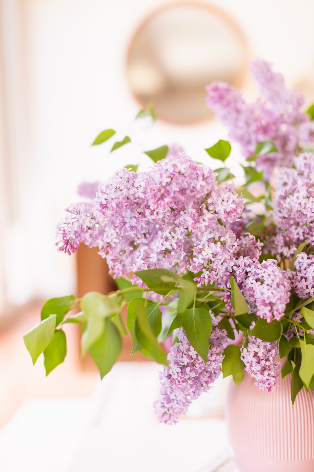 Details of an oversized lilac bouquet on a white coffee table in JustineCelina’s light and airy mid century meets boho modern living room | DIY Lilac Flower Arrangement | How to Forage Lilacs | How to Prolong Lilac Vase Life | How to Arrange Lilacs | Fresh Lilac Flower Bouquet | Extremely Pretty Lilac Arrangement | Purple Lilac Arrangement | How to Cut Lilacs from a tree or bush | Calgary Creative Lifestyle Blogger // JustineCelina.com