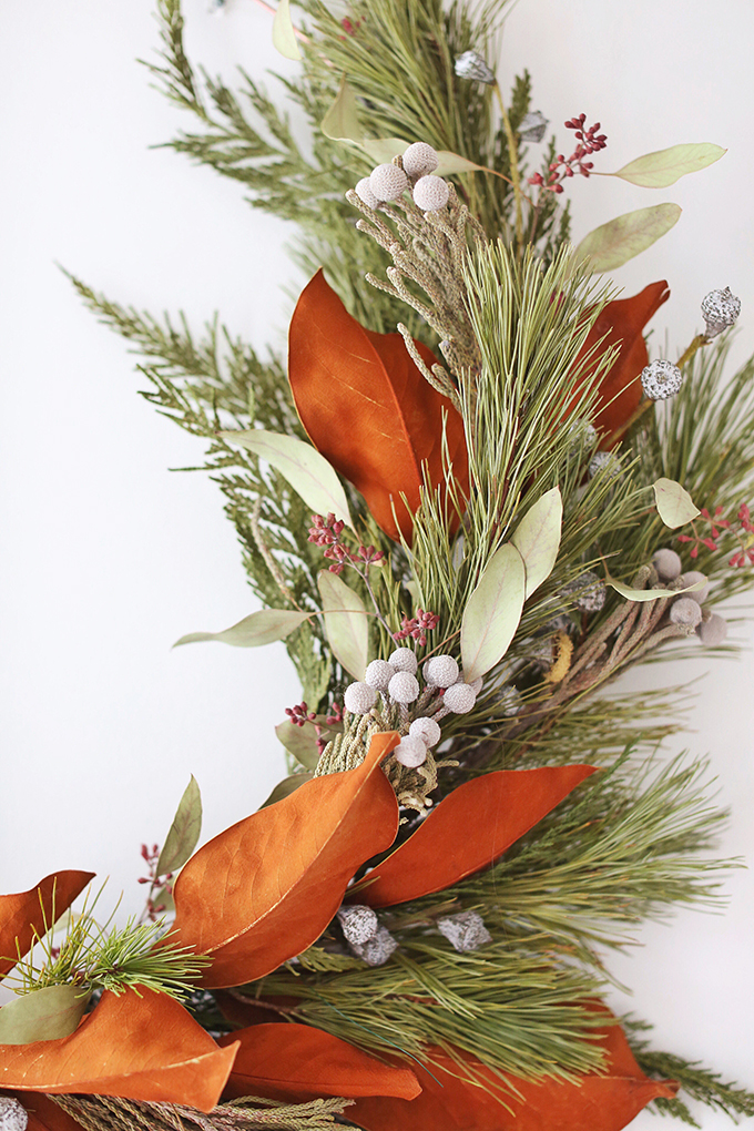 DIY | Asymmetrical Holiday Wreath | How to Make an Asymmetrical Holiday Wreaths for Christmas with Pine, Cedar, Brunia, Eucalyptus pods, Red Ironbark Eucalyptus and Magnolia | Christmas Wreath DIY | Modern Christmas Wreath DIY // JustineCelina.com