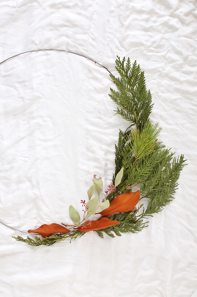 DIY | Asymmetrical Holiday Wreath | How to Make an Asymmetrical Holiday Wreaths for Christmas with Pine, Cedar, Brunia, Eucalyptus pods, Red Ironbark Eucalyptus and Magnolia | Christmas Wreath DIY | Modern Christmas Wreath DIY // JustineCelina.com