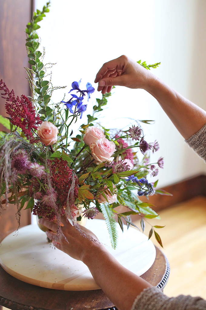 A PANTONE 2018 Ultra Violet Inspired Arrangement with Anemones, Spray Roses, Bella Donna, Dephinium, Astrantia, Astilbe, Sedum, Ruby Silk Grass, Nandina, Umbrella Fern and Knife blade Acacia | Step by Step Flower Arranging Guide // JustineCelina.com x Rebecca Dawn Design