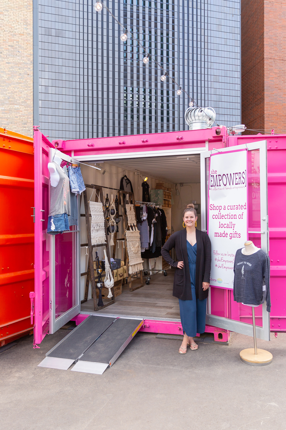 Exploring East Village Junction with Tourism Calgary | Vibrant Inglewood Calgary Summer Market with container stores, live performances, food trucks, vegan food, eclectic shopping, bike rentals and fitness classes | Alora Boutique Review | A woman standing infront of a hot pink shipping container converted into a boutique at and outdoor market // JustineCelina.com