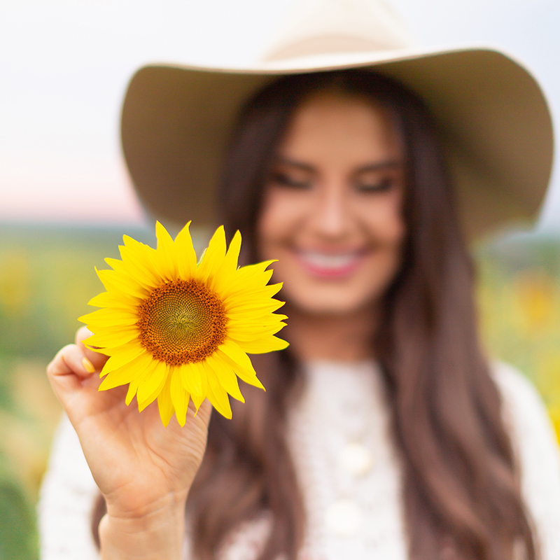 September 2018 Soundtrack | Girl Holding a Sunflower in the Bowden Sunmaze, Alberta, Canada | Calgary Lifestyle Blogger // JustineCelina.com