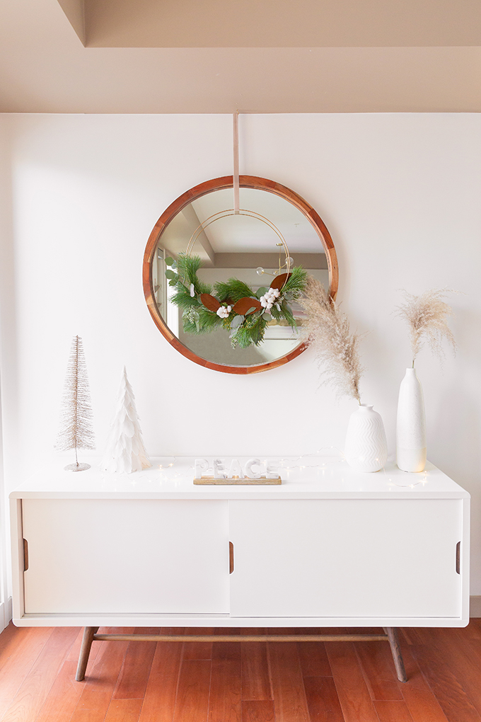 Apartment Friendly Modern Holiday Decor | DIY Modern Holiday Wreath with Magnolia Leaves, Cotton, Silver Dollar Eucalyptus, Seeded Eucalyptus, Cedar and Insense Cedar | Bohemian Holiday Home Tour 2018 | Caramel Mid Century Modern Leather Couches | Canadian Tire CANVAS Ornaments // JustineCelina.com