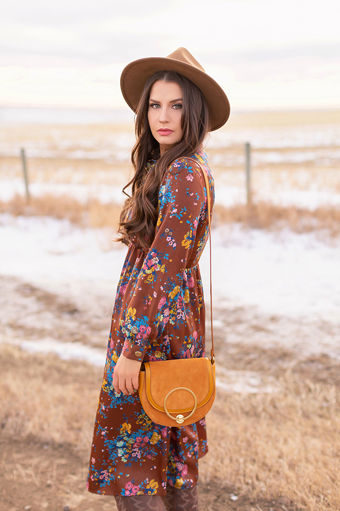 Winter 2019 Lookbook | Bohemian Rhapsody: How to Style Midi Dresses for Winter | Brunette Girl Standing in a Country Field at Sunrise Wearing a Brown Floral Dress, Brown Wide Brim Hat and a Mustard Cross Body Bag | Bohemian Winter Style Ideas | Pantone Spring Summer 2019 Fashion Ideas | Calgary, Alberta, Canada Fashion & Lifestyle Blogger // JustineCelina.com