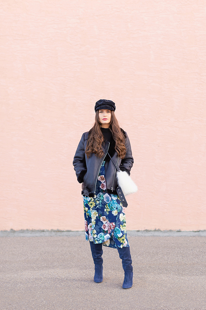 Winter 2019 Lookbook | Edgy Florals: How to Style Midi Skirts for Winter | 3rd Floor Studio Angie Skirt paired with Blue Maroco Women's Over-the-knee suede boots, a black turtleneck and a longline, lined biker jacket with a black velvet baker boy hat and a white faux fur bag | How to Style a Biker Jacket for Winter // JustineCelina.com