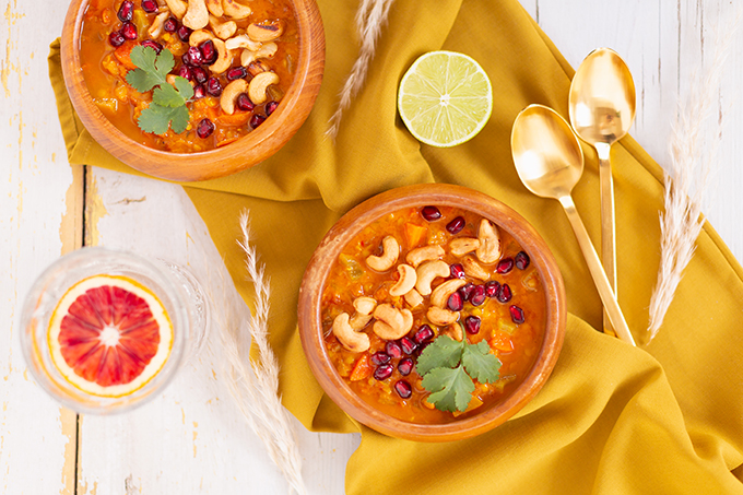 Slow Cooker Vegan Mulligatawny Soup with Red Lentils | #vegan #glutenfree | A warm bowl of vegan mulligatawny soup garnished with roasted cashews, pomegranate arils and cilantro with gold spoons and citrus water | The best vegan mulligatawny soup slow cooker recipe | vegetarian mulligatawny soup | vegetarian mulligatawny soup recipe lentils | vegetarian mulligatawny soup slow cooker | mulligatawny soup crock pot | best winter vegan slow cooker recipes // JustineCelina.com