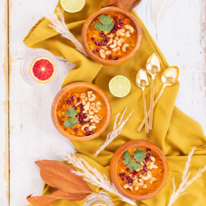 Slow Cooker Vegan Mulligatawny Soup with Red Lentils | #vegan #glutenfree | A warm bowl of vegan mulligatawny soup garnished with roasted cashews, pomegranate arils and cilantro with gold spoons and citrus water | The best vegan mulligatawny soup slow cooker recipe | vegetarian mulligatawny soup | vegetarian mulligatawny soup recipe lentils | vegetarian mulligatawny soup slow cooker | mulligatawny soup crock pot | best winter vegan slow cooker recipes // JustineCelina.com