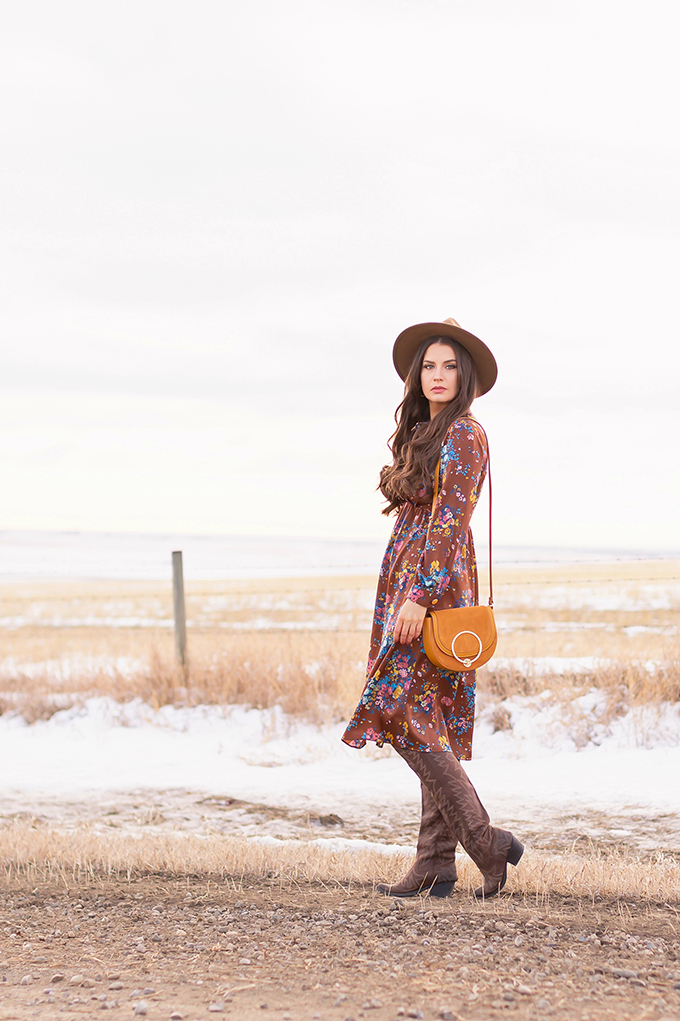 Pre Spring 2019 Trend Guide Bohemian Rhapsody: How to Style Midi Dresses for Transitional Spring Weather | Brunette Girl Standing in a Country Field at Sunrise Wearing a Brown Floral Dress, Brown Wide Brim Hat and a Mustard Cross Body Bag | Bohemian Winter Style Ideas | Pantone Spring Summer 2019 Fashion Ideas | Calgary, Alberta, Canada Fashion & Lifestyle Blogger // JustineCelina.com