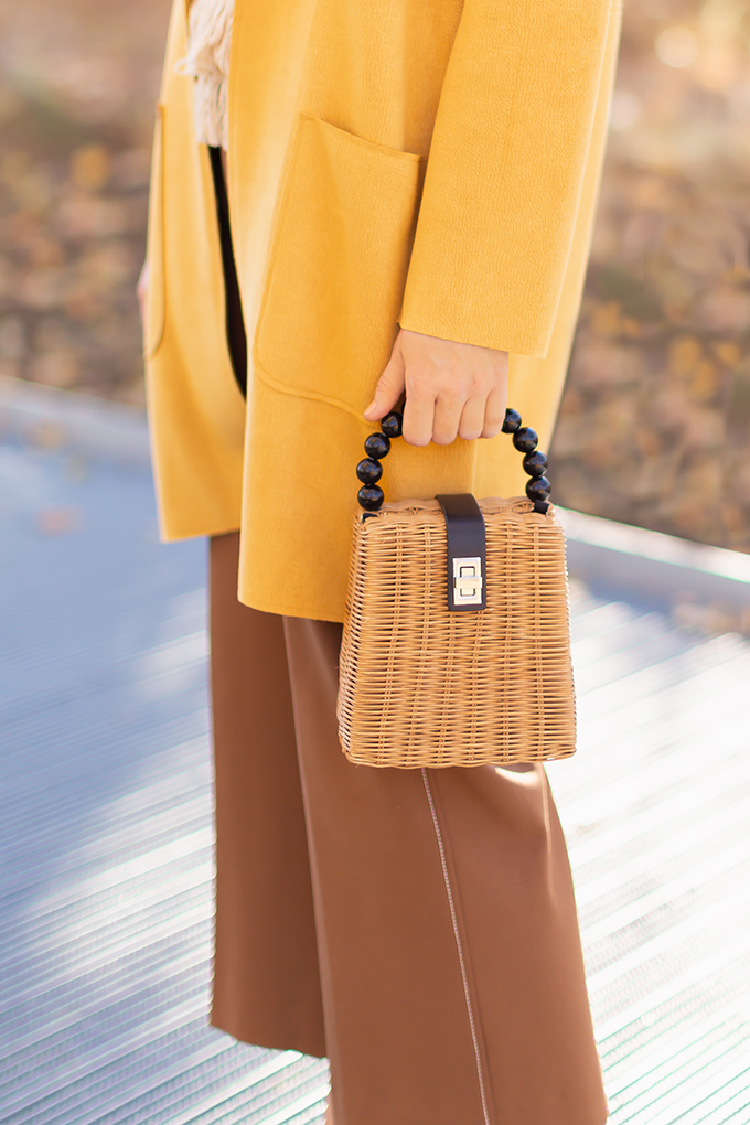 WORK WEAR | SPRING 2019 TRENDS AT THE OFFICE | How to Style Culottes for the Office | Brown 70’s Style Culottes with a Mustard Faux Suede Jacket, Knit Fringe Hem Top, Natural Material Zara Rattan Woven Box Bag and Leopard Print D’Orsay Heels | Alex & Ani Hand of Fatima Bracelet | Spring 2019 Trends | Office Appropriate Spring Outfit Ideas // JustineCelina.com