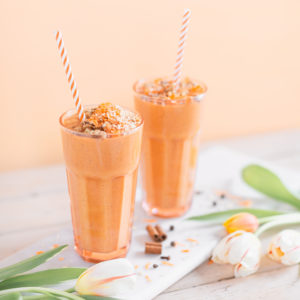 Vegan Cardamom Carrot Cake Smoothie | healthy carrot cake smoothie, cardamom carrot cake smoothie recipe, cardamom carrot cake smoothie vegan, cardamom carrot cake smoothie image, cardamom carrot cake smoothies, paleo carrot cake smoothie, vegan paleo carrot cake smoothie, the best vegan carrot cake smoothie, 2 carrot cake smoothies with spring tulips against a creamsicle orange pastel background and a marble serving board | Calgary, Alberta Creative Lifestyle Blogger // JustineCelina.com