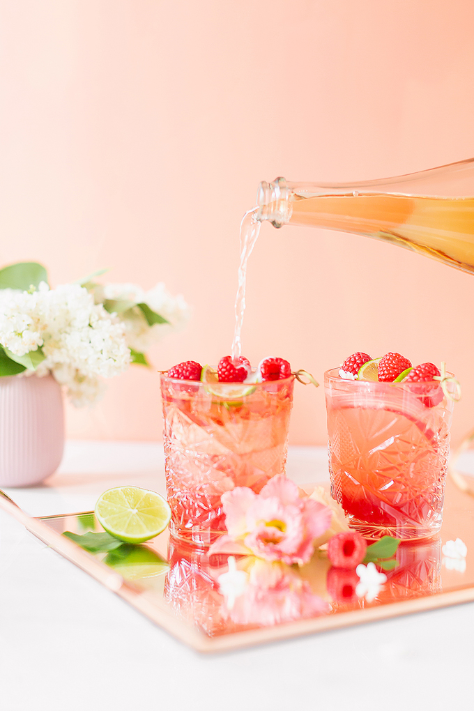 Raspberry Rhubarb Rosé Spritz | A refreshing, clean, refined sugar free cocktail | A summer-inspired trio of rhubarb, raspberries and honey combine in a scratch-made Honeyed Raspberry Rhubarb Syrup to infuse this effervescent cocktail with seasonal panache, beautifully complimented by sparkling rosé, soda water, fresh lime juice and a dash of bitters | Rosé spritzer recipe | Rosé cocktail | Rosé wine spritzer | summer cocktails with vodka // JustineCelina.com