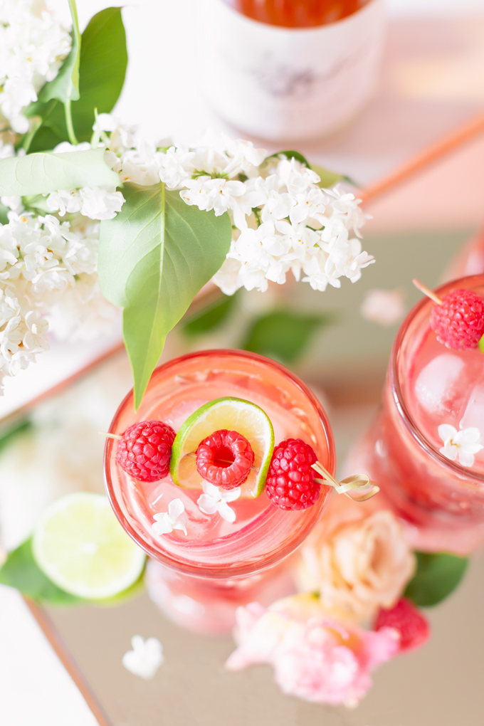 Raspberry Rhubarb Rosé Spritz | A refreshing, clean, refined sugar free cocktail | A summer-inspired trio of rhubarb, raspberries and honey combine in a scratch-made Honeyed Raspberry Rhubarb Syrup to infuse this effervescent cocktail with seasonal panache, beautifully complimented by sparkling rosé, soda water, fresh lime juice and a dash of bitters | Rosé spritzer recipe | Rosé cocktail | Rosé wine spritzer | summer cocktails with vodka // JustineCelina.com