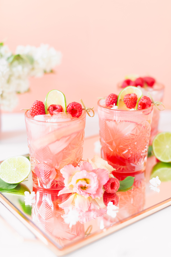 Raspberry Rhubarb Rosé Spritz | A refreshing, clean, refined sugar free cocktail | A summer-inspired trio of rhubarb, raspberries and honey combine in a scratch-made Honeyed Raspberry Rhubarb Syrup to infuse this effervescent cocktail with seasonal panache, beautifully complimented by sparkling rosé, soda water, fresh lime juice and a dash of bitters | Rosé spritzer recipe | Rosé cocktail | Rosé wine spritzer | summer cocktails with vodka // JustineCelina.com