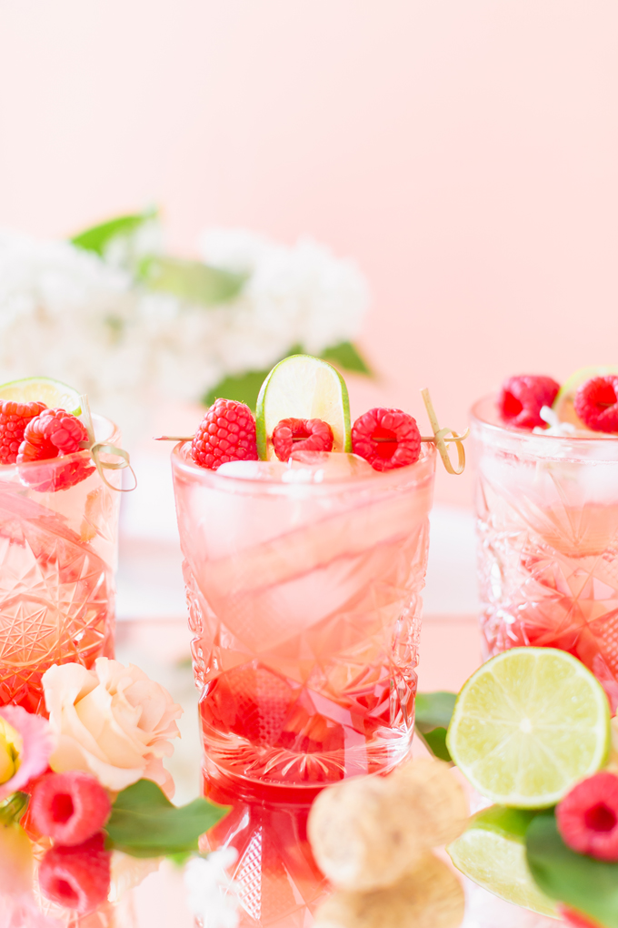 Raspberry Rhubarb Rosé Spritz | A refreshing, clean, refined sugar free cocktail | A summer-inspired trio of rhubarb, raspberries and honey combine in a scratch-made Honeyed Raspberry Rhubarb Syrup to infuse this effervescent cocktail with seasonal panache, beautifully complimented by sparkling rosé, soda water, fresh lime juice and a dash of bitters | Rosé spritzer recipe | Rosé cocktail | Rosé wine spritzer | summer cocktails with vodka // JustineCelina.com