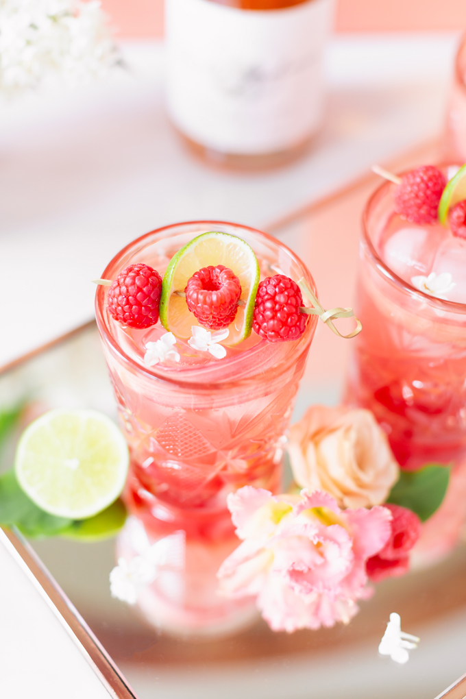 Raspberry Rhubarb Rosé Spritz | A refreshing, clean, refined sugar free cocktail | A summer-inspired trio of rhubarb, raspberries and honey combine in a scratch-made Honeyed Raspberry Rhubarb Syrup to infuse this effervescent cocktail with seasonal panache, beautifully complimented by sparkling rosé, soda water, fresh lime juice and a dash of bitters | Rosé spritzer recipe | Rosé cocktail | Rosé wine spritzer | summer cocktails with vodka // JustineCelina.com