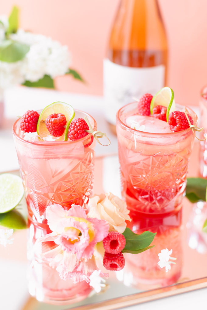 Raspberry Rhubarb Rosé Spritz | A refreshing, clean, refined sugar free cocktail | A summer-inspired trio of rhubarb, raspberries and honey combine in a scratch-made Honeyed Raspberry Rhubarb Syrup to infuse this effervescent cocktail with seasonal panache, beautifully complimented by sparkling rosé, soda water, fresh lime juice and a dash of bitters | Rosé spritzer recipe | Rosé cocktail | Rosé wine spritzer | summer cocktails with vodka // JustineCelina.com