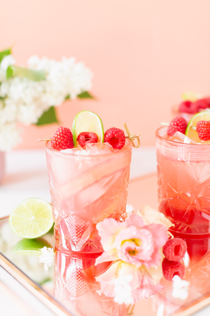 Raspberry Rhubarb Rosé Spritz | A refreshing, clean, refined sugar free cocktail | A summer-inspired trio of rhubarb, raspberries and honey combine in a scratch-made Honeyed Raspberry Rhubarb Syrup to infuse this effervescent cocktail with seasonal panache, beautifully complimented by sparkling rosé, soda water, fresh lime juice and a dash of bitters | Rosé spritzer recipe | Rosé cocktail | Rosé wine spritzer | summer cocktails with vodka // JustineCelina.com