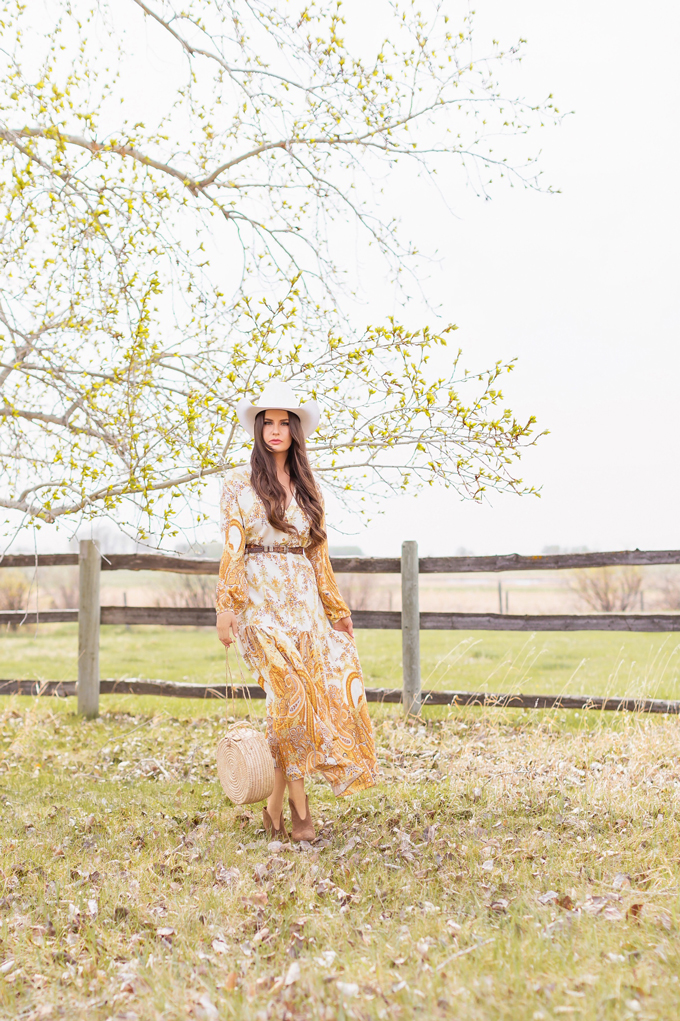 How to Style | Calgary’s White Hat for The Stampede | Stampede 2019 Outfit Ideas | Brunette Woman wearing a flow Paisley dress with a vintage western belt, Smithbilt The White Hat in White Felt and mid heel ankle boots with a round rattan bag | Smithbilt White Hat Outfit | How to Style a Cowboy Hat for the Calgary Stampede | Calgary Stampede Dress Code | Bohemian Western Inspired Outfit Summer 2019 | Boho Stampede Style | Justine Celina Maguire x Tourism Calgary // JustineCelina.com