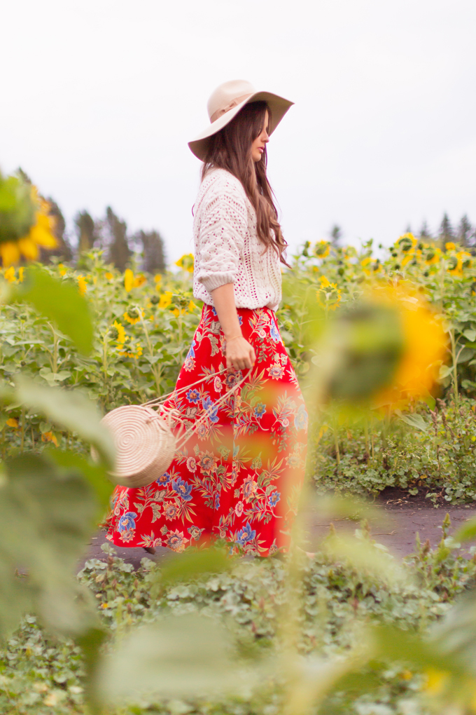 LATE SUMMER 2019 LOOKBOOK | Crimson and Clover: How to Style Maxi Dresses for Summer / Autumn | Red Maxi Dress Outfit Ideas | Bohemians Transitional Outfit Ideas | Brunette woman wearing a floral printed red maxi dress with a fisherman’s knit sweater, floppy felt tan hat and a woven round bag in a sunflower field | Canadian sunflower field in Alberta at Sunset | Bowden Sunmaze Review | Calgary, Alberta, Canada Lifestyle and Fashion Blogger, Justine Celina Maguire | JustineCelina.com