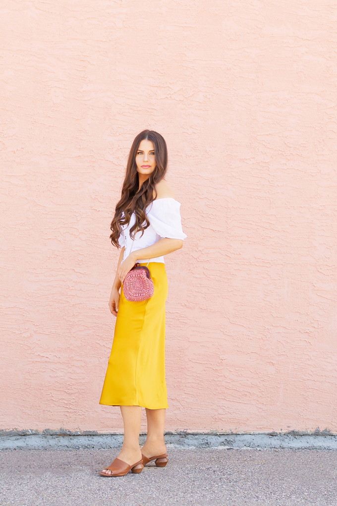 LATE SUMMER 2019 LOOKBOOK | Walking on Sunshinet: How to Style TopShop’s Bias Cut Satin Midi Skirt for Summer / Autumn | TopShop Yellow Satin Skirt Outfit Ideas | Casual Daytime Transitionl Outfit Ideas | Brunette woman wearing a Topshop Yellow Satin Midi Skirt styled with a white button-down Bardot top, brown leather mules with a wooden heel and a Pantone Living Coral beaded bag | Summer 2019 Trends | Calgary Fashion & Creative Lifestyle Blogger // JustineCelina.com