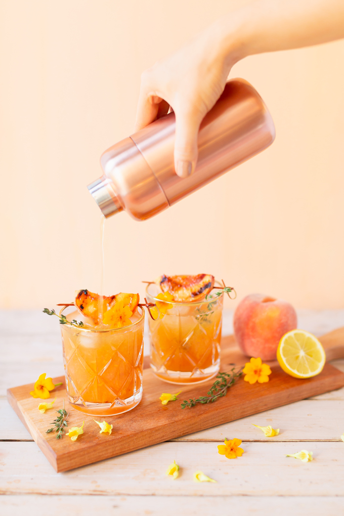 Smoked Peach Maple Bourbon Smash | A summer-meets-autumn sip juxtaposing juicy late summer fruit with a smoky grilled edge and spicy autumnal warmth | Dairy Free, Gluten Free and Refined Sugar Free -- and brimming with better-for-you ingredients! | The best fresh peach bourbon cocktail recipe | Grilled peach cocktail | Peach Bourbon Cocktail | Late summer bourbon cocktails | Southern Summer Peach Cocktail | Early Autumn Peach Cocktail | Autumn Equinox Cocktail Recipe // JustineCelina.com