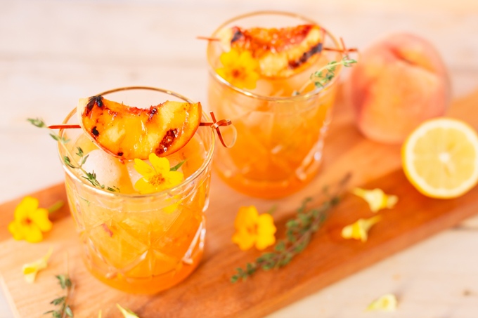 Smoked Peach Maple Bourbon Smash | A summer-meets-autumn sip juxtaposing juicy late summer fruit with a smoky grilled edge and spicy autumnal warmth | Dairy Free, Gluten Free and Refined Sugar Free -- and brimming with better-for-you ingredients! | The best fresh peach bourbon cocktail recipe | Grilled peach cocktail | Peach Bourbon Cocktail | Late summer bourbon cocktails | Southern Summer Peach Cocktail | Early Autumn Peach Cocktail | Autumn Equinox Cocktail Recipe // JustineCelina.com