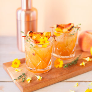 Smoked Peach Maple Bourbon Smash | A summer-meets-autumn sip juxtaposing juicy late summer fruit with a smoky grilled edge and spicy autumnal warmth | Dairy Free, Gluten Free and Refined Sugar Free -- and brimming with better-for-you ingredients! | The best fresh peach bourbon cocktail recipe | Grilled peach cocktail | Peach Bourbon Cocktail | Late summer bourbon cocktails | Southern Summer Peach Cocktail | Early Autumn Peach Cocktail | Autumn Equinox Cocktail Recipe // JustineCelina.com