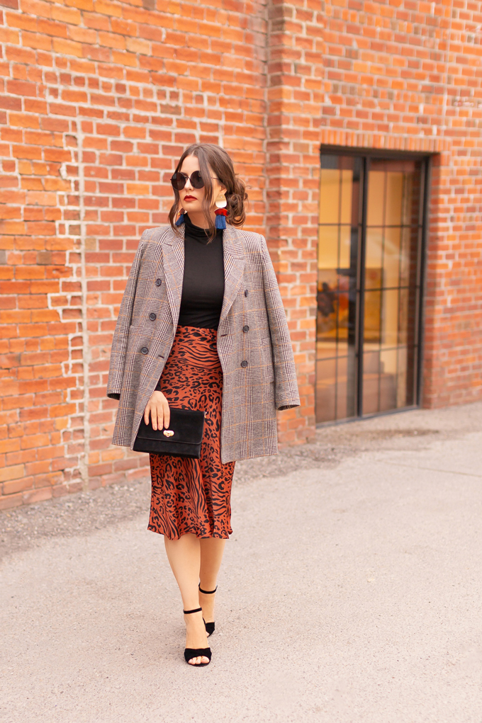 Autumn 2019 Lookbook: Cheetah Chic | Top Fall / Winter 2019 Trends | Top Autumn 2019 Trends and How to Wear Them | Brunette woman wearing a burnt orange cheetah print satin midi skirt, black turtleneck, oversized plaid blazer, black velvet sandals and a vintage suede bag | Chic Fall / Winter 2019 Evening Outfits | How to Style Cheetah Print | How to Style Boyfriend Blazers | How to Mix Prints | Top Calgary Fashion & Creative Lifestyle Blogger // JustineCelina.com