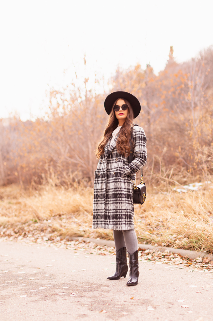 Autumn / Winter 2019 Lookbook: Checked Cowgirl | Top Fall / Winter 2019 / 2020 Trends | Top Winter 2019 Trends and How to Wear Them | Brunette woman wearing a Vero Moda Wool Plaid Coat, Ruffled, Tie Neck Blouse, Grey ripped skinny jeans, Zara Heeled Leather Wedge Cowboy Boots, a black Chloe Tess dupe and a black wide brimmed black hat | Bohemian Canadian Winter Outfit Ideas | Western Winter Outfit Ideas | How to Style a Plaid Coat | Top Calgary Fashion Blogger // JustineCelina.com