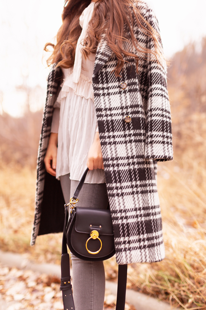 Autumn / Winter 2019 Lookbook: Checked Cowgirl | Top Fall / Winter 2019 / 2020 Trends | Top Winter 2019 Trends and How to Wear Them | Brunette woman wearing a Vero Moda Wool Plaid Coat, Ruffled, Tie Neck Blouse, Grey ripped skinny jeans, Zara Heeled Leather Wedge Cowboy Boots, a black Chloe Tess dupe and a black wide brimmed black hat | Bohemian Canadian Winter Outfit Ideas | Western Winter Outfit Ideas | How to Style a Plaid Coat | Top Calgary Fashion Blogger // JustineCelina.com