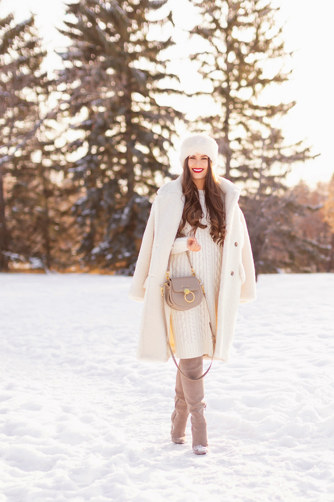 Autumn / Winter 2019 Lookbook: Winter Whites | Top Fall / Winter 2019 / 2020 Trends | Top Winter 2019 Trends and How to Wear Them | Brunette woman wearing a Mango Oversized Cream Teddy Coat, Cream Cable Knit Sweater Dress, Grey Over The Knee Boots and Grey Chloe Tess Dupe | Monochromatic Cream / White Outfit | Festive Winter Holiday Outfit | Christmas Dinner Outfit | Canadian Winter Outfit Ideas | Fenty Stunna Lip Paint in Uncensored | Top Calgary Fashion & Lifestyle Blogger // JustineCelina.com