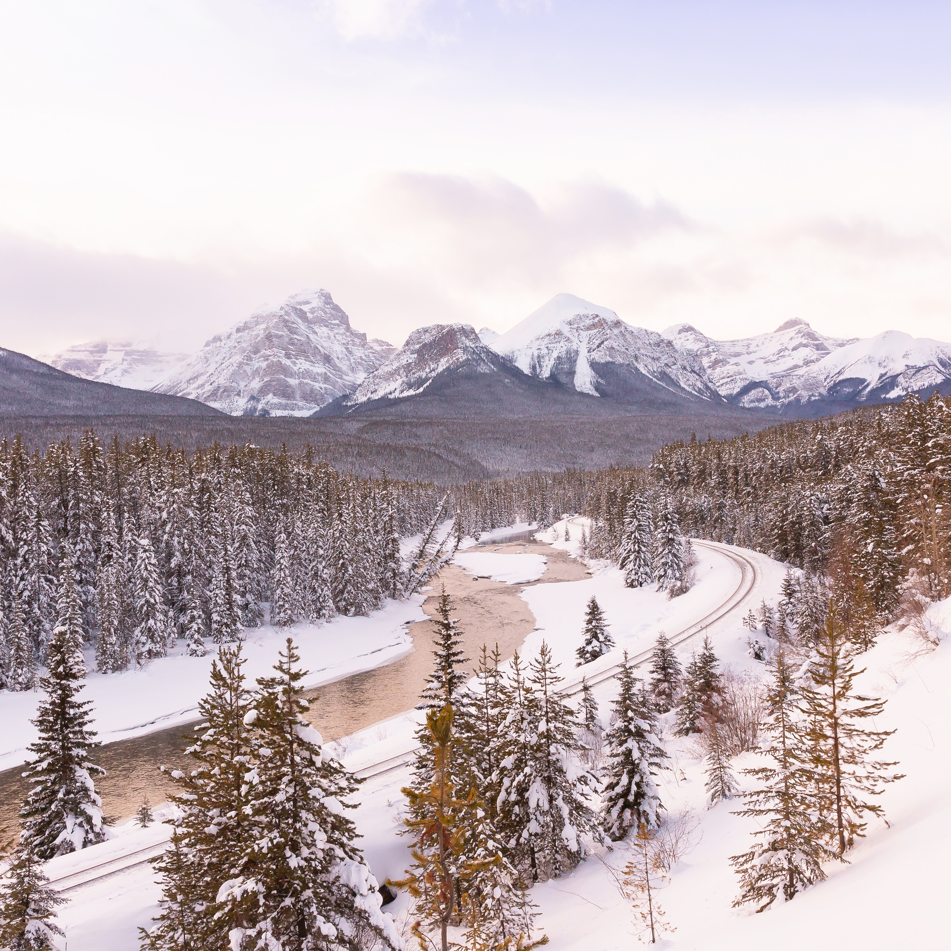 Hello 2020 | Morants Curve Photos | Morant’s Curve Winter 2020 at Sunset | Bow Valley Parkway Winter 2020 | Bow Valley Winter | Highway 1a Banff to Lake Louise Lookouts | Canmore Scenic Drive | Best Things To do in Lake Louise Canada During the Winter | Getting to Lake Louise | Canadian at Morant's Curve | Snow Covered Canadian Mountain River Valley | The best winter scenic drives in the Canadian Rockies | Calgary Travel and Lifestyle Blogger // JustineCelina.com