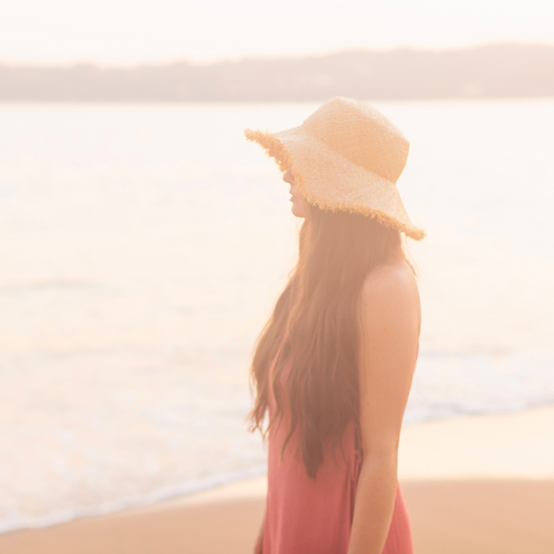 January 2020 Soundtrack | Brunette woman overlooking Tangolunda Bay at Sunset wearing a frayed brim straw hat and a coral dress | Camino Real Zaashila, Huatulco Review | Camino Real Resort Huatulco 2020 | Tangolunda Bay | Calgary Lifestyle, Fashion & Travel Blogger // JustineCelina.com