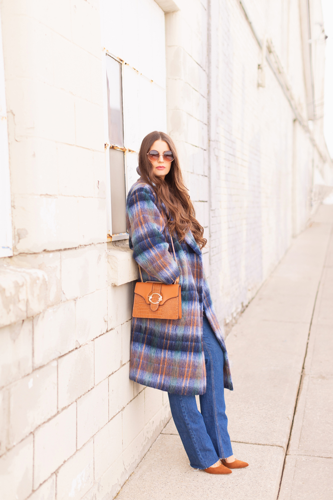 Colour Crush: Classic Blue | Brunette woman wearing a Classic Blue UO Oversized Plaid Wool Overcoat, Zara Straight Leg Blue Jeans, Mango Cognac Asymmetric Stiletto Shoes, H&M Brown Knit Turtleneck Sweater, TopShop Croc Embossed Crossbody Bag and Brown Circular Sunglasses in an urban Setting | How to Wear Pantone’s 2020 Color of the Year, Classic Blue | Pantone Color of The Year 2020 Fashion | Transitional Winter to Spring Fashion for Canadians | Calgary Fashion Blogger // JustineCelina.com