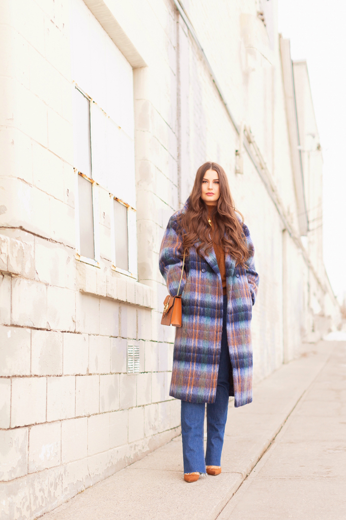 Colour Crush: Classic Blue | Brunette woman wearing a Classic Blue UO Oversized Plaid Wool Overcoat, Zara Straight Leg Blue Jeans, Mango Cognac Asymmetric Stiletto Shoes, H&M Brown Knit Turtleneck Sweater, TopShop Croc Embossed Crossbody Bag and Brown Circular Sunglasses in an urban Setting | How to Wear Pantone’s 2020 Color of the Year, Classic Blue | Pantone Color of The Year 2020 Fashion | Transitional Winter to Spring Fashion for Canadians | Calgary Fashion Blogger // JustineCelina.com