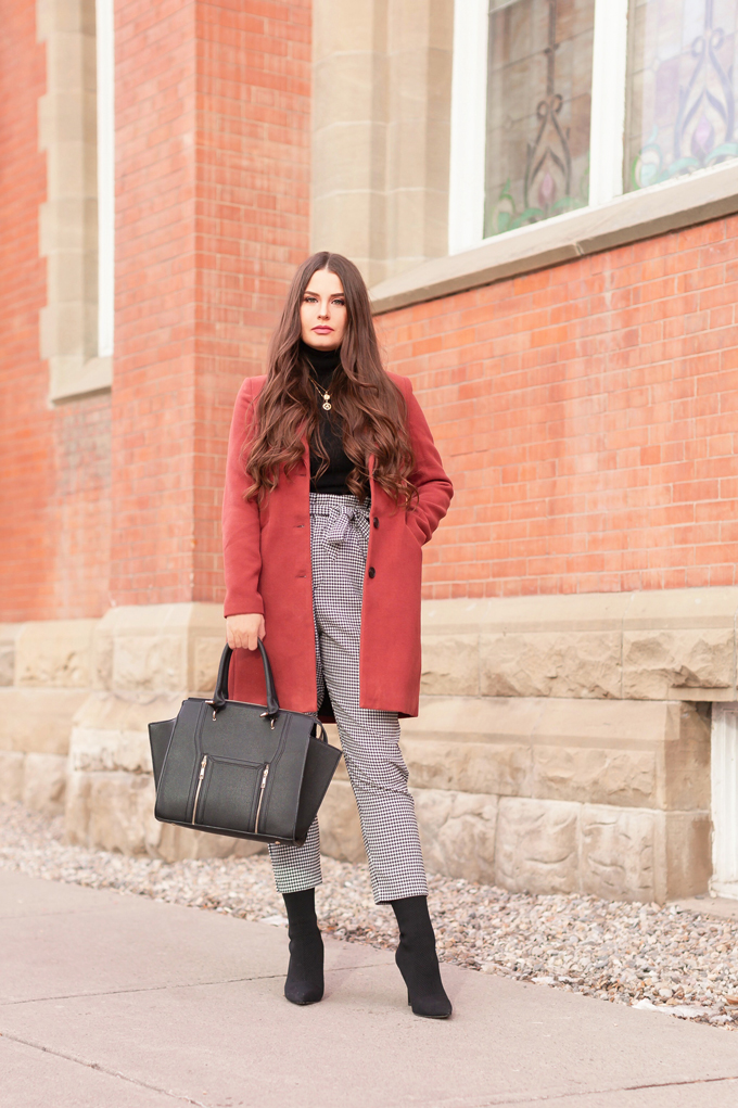 WINTER / SPRING 2020 LOOKBOOK | Boss Babe | Brunette woman wearing a Vero Moda Rust Dress Coat, H&M Houndstooth Paperbag Pants, Black Saks 5th Avenue Cashmere Turtleneck, Lulus Back Wing Woman Handbag and Zara Black Sock Boots | Professional Winter to Spring Outfit Ideas | Top Transitional Winter to Spring 2020 Trends | Canadian Winter / Spring Lookbook | How to Wear Spring 2020’s Mini Dress | Transitional Winter to Spring Fashion for Canadians // JustineCelina.com