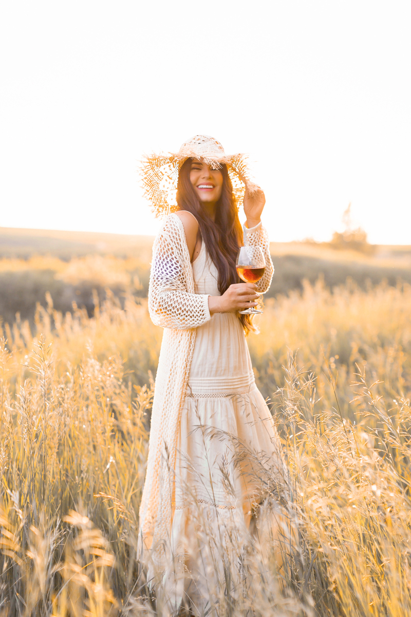 June 2020 Soundtrack | Chill Summer Playlist | Inspiring Summer Playlist Spotify | Laughing brunette woman enjoying a glass of rosé wine in a sunlit prairie wheat field at sunset | JustineCelina’s childhood home in Wheatland County, Alberta | Summer 2020 Bohemian Style Ideas | Boho Casual Summer Dresses | Summer 2020 Fashion | Best H&M Dresses Summer 2020 | How to Style a Frayed Brim Straw Hat | Calgary, Alberta, Canada Creative Lifestyle Blogger and Entrepreneur// JustineCelina.com