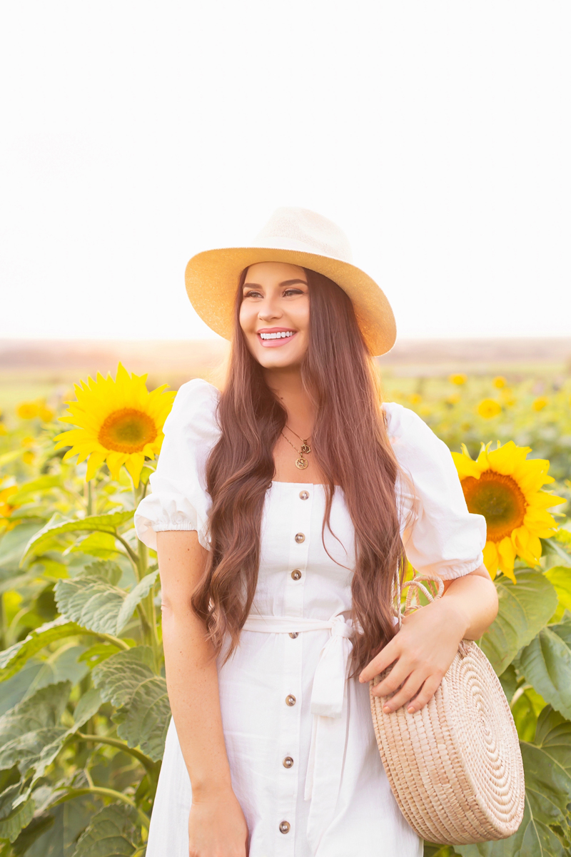 A Guide to Bowden SunMaze & Eagle Creek Farms | Bowden SunMaze September 2020 | Sunflower Field Near Me | The Best Alberta Sunflower Field | Alberta Sunflower U-Pick | Bowden SunMaze Sunflower Field Best Time To Go | Bowden SunMaze Cost | Eagle Creek Farms Review | Sunflower Field Instagram Tips | Cottagecore Aesthetic | Smiling brunette woman wearing a cream Crêped Cotton Dress and woven fedora laughing in a field of sunflowers at sunset | Calgary Lifestyle Blogger // JustineCelina.com