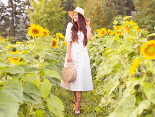 A Guide to Bowden SunMaze & Eagle Creek Farms | Bowden SunMaze September 2020 | Sunflower Field Near Me | The Best Alberta Sunflower Field | Alberta Sunflower U-Pick | Bowden SunMaze Sunflower Field Best Time To Go | Bowden SunMaze Cost | Eagle Creek Farms Review | Sunflower Field Instagram Tips | Cottagecore Aesthetic | Smiling brunette woman wearing a cream Crêped Cotton Dress and woven fedora laughing in a field of sunflowers at sunset | Calgary Lifestyle Blogger // JustineCelina.com