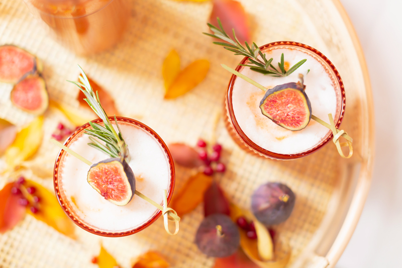 Rosemary Fig Japanese Whisky Sour | A Whisky Sour Cocktail with a Fresh Fig Garnish on a Rattan Serving Tray with Autumn Leaves and a Brass Cocktail Shaker in the Background | Autumn Whiskey Cocktails | Best Fall Whisky Cocktail Recipes | Fall Fig Cocktail | Fall Summer Cocktail | Fig Cocktail Syrup | Japanese Whisky Cocktail | Nikka Super Rare Old Cocktail | Nikka Cocktail | Whiskey Sour With Egg | Calgary Cocktail Photographer and Stylist | Calgary Lifestyle Blogger // JustineCelina.com