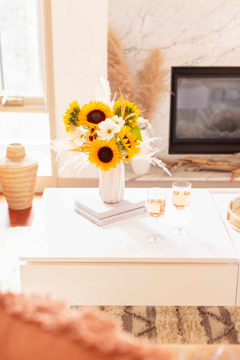 Our Transitional Summer Meets Autumn Decor | Summer to Fall Decor | September Decorations | Sunflower Decor | Easy Fall Decorating Ideas 2020 | Affordable Fall Decor | Simple Fall Decor Ideas | Fall Apartment Decor JustineCelina’s Inner City Calgary bohemian, mid-century modern Living Room | Cheerful Sunflower Arrangement with white Cosmos and Pampas Grass on a coffee table with 2 glasses of rosé | Summer Meets Autumn Decor | Sunflower Decor Ideas | Calgary Lifestyle Blogger // JustineCelina.com