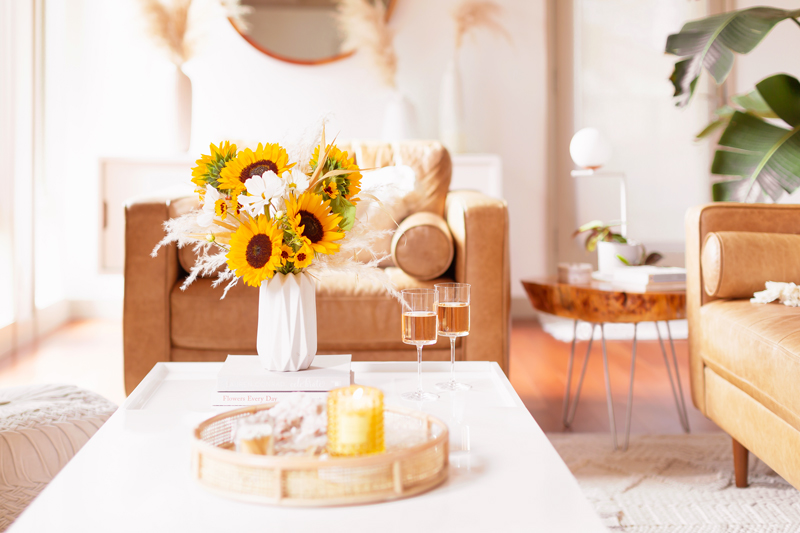 Our Transitional Summer Meets Autumn Decor | Summer to Fall Decor | September Decorations | Sunflower Decor | Easy Fall Decorating Ideas 2020 | Affordable Fall Decor | Simple Fall Decor Ideas | Fall Apartment Decor JustineCelina’s Inner City Calgary bohemian, mid-century modern Living Room | Cheerful Sunflower Arrangement with white Cosmos and Pampas Grass on a coffee table with 2 glasses of rosé | Summer Meets Autumn Decor | Sunflower Decor Ideas | Calgary Lifestyle Blogger // JustineCelina.com