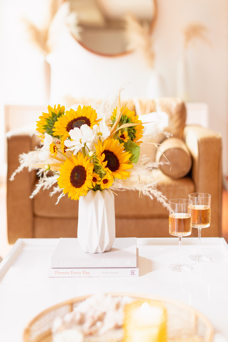 Our Transitional Summer Meets Autumn Decor | Summer to Fall Decor | September Decorations | Sunflower Decor | Easy Fall Decorating Ideas 2020 | Affordable Fall Decor | Simple Fall Decor Ideas | Fall Apartment Decor JustineCelina’s Inner City Calgary bohemian, mid-century modern Living Room | Cheerful Sunflower Arrangement with white Cosmos and Pampas Grass on a coffee table with 2 glasses of rosé | Summer Meets Autumn Decor | Sunflower Decor Ideas | Calgary Lifestyle Blogger // JustineCelina.com