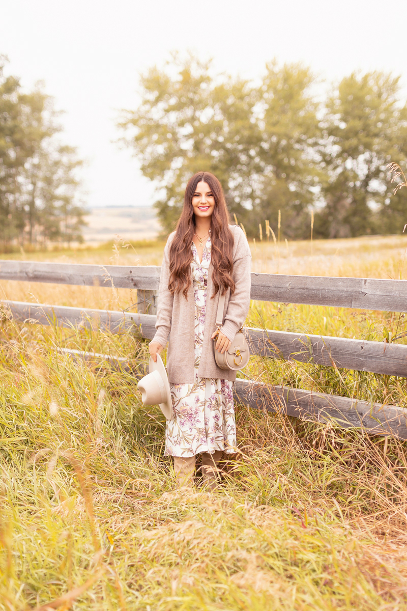 Early Autumn 2020 Lookbook | Country Checks | Brunette woman wearing a botanical print button down midi dress, a Chloe Tess Bag in Grey, knee high suede pointed toe boots and a taupe flat brimmed hat next to an weathered fence in the prairies | Boho Fall 2020 Outfit Ideas | Top Fall 2020 Trends | How to Style Midi Dresses for Fall | Bohemian Fall outfit Ideas | How to Wear Florals in Fall | Cottagecore Fall Outfit Ideas | Calgary Alberta Fashion & Lifestyle Blogger // JustineCelina.com