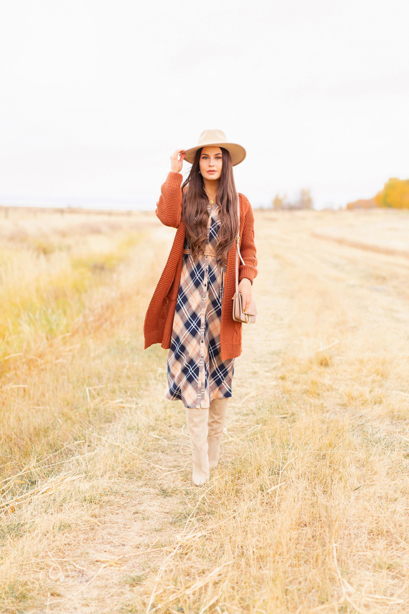 Early Autumn 2020 Lookbook | Brunette woman wearing a taupe flat brimmed fedora, a taupe, rust longline cardigan, orange and navy blue plaid dress, tan crossbody bag and knee high tan suede pointed toe boots | Boho Fall 2020 Outfit Ideas | Top Fall 2020 Trends | Fall on the Alberta Prairies | Thanksgiving Outfit Idea | Bohemian Fall outfit Ideas | Monochromatic Plaid Outfit Ideas | Cottagecore Fall Outfit Ideas | Calgary Alberta Fashion & Lifestyle Blogger // JustineCelina.com