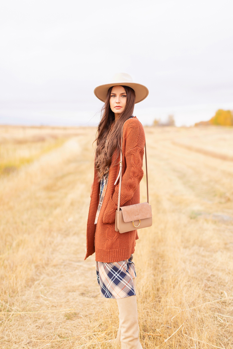 Early Autumn 2020 Lookbook | Country Checks | Brunette woman wearing a taupe flat brimmed fedora, a taupe, rust longline cardigan, orange and navy blue plaid dress, tan crossbody bag and knee high tan suede pointed toe boots | Boho Fall 2020 Outfit Ideas | Top Fall 2020 Trends | Fall on the Alberta Prairies | Thanksgiving Outfit Idea | Bohemian Fall outfit Ideas | Monochromatic Plaid Outfit Ideas | Cottagecore Fall Outfit Ideas | Calgary Alberta Fashion & Lifestyle Blogger // JustineCelina.com