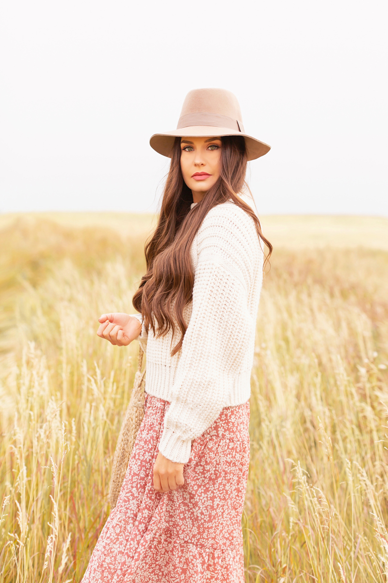 Early Autumn 2020 Lookbook | Prairie Chic | Brunette woman wearing a rose floral midi dress, a chunky cream knit, a tan felt fedora and a round jute bag in a wheat field | Boho Fall 2020 Outfit Ideas | Top Fall 2020 Trends | Fall on the Alberta Prairies | Thanksgiving Outfit Idea | Bohemian Fall outfit Ideas | The Best H&M Knitwear | Cottagecore Fall Outfit Ideas | How to Style Summer Dresses Into Fall | Calgary Alberta Fashion & Lifestyle Blogger // JustineCelina.com