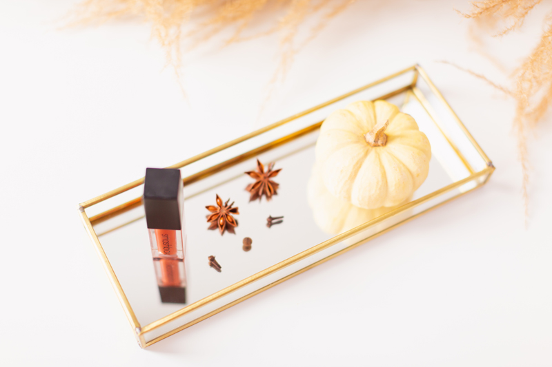 My Top 5 Pumpkin Spice Lipsticks | JustineCelina’s favourite fall lipsticks | The Best Pumpkin Spice Lipsticks for Fall | Fall 2020 Lipstick Trends | Smashbox Always On Matte Liquid Lipstick in Out Loud Photos Review Swatches and Du[es | Light / Medium Skintone | The Best Drugstore Fall Lipsticks | The Best Pumpkin Spice Lipsticks for Fall | Lipstick on a Mirrored Tray with spices, a white mini pumpkin and pampas grass in the background | Calgary Beauty Blogger // JustineCelina.com