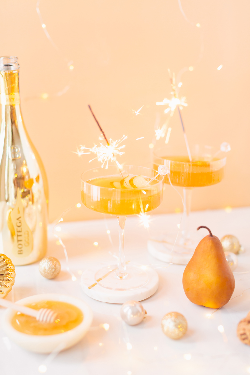 Gilded Vanilla Pear Sparkler | A glitzy, French 75 inspired New Years Eve cocktail featuring 24 karat gold infused gin, Bottega Gold Prosecco, Italian vanilla liqueur, lemon juice and Honeyed Vanilla Pear Syrup | Best NYE 2020 cocktails | How to Make sparkling NYE cocktails at home | Champagne cocktail recipe | Champagne Christmas drinks | New Years Eve Sparklers | Refined Sugar Free French 75 | NYE Cocktail Party Recipes | Calgary Creative Lifestyle & Cocktail Blogger // JustineCelina.com