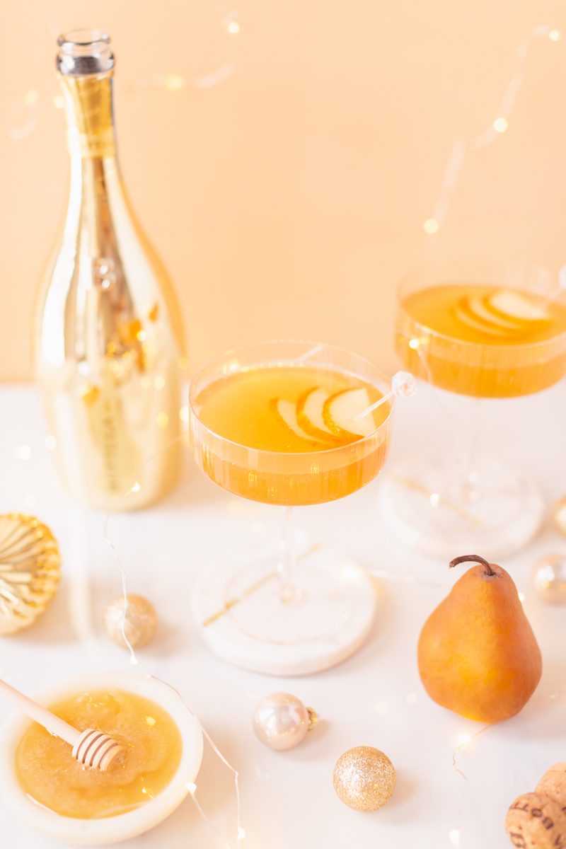 Gilded Vanilla Pear Sparkler | A glitzy, French 75 inspired New Years Eve cocktail featuring 24 karat gold infused gin, Bottega Gold Prosecco, Italian vanilla liqueur, lemon juice and Honeyed Vanilla Pear Syrup | Best NYE 2020 cocktails | How to Make sparkling NYE cocktails at home | Champagne cocktail recipe | Champagne Christmas drinks | New Years Eve Sparklers | Refined Sugar Free French 75 | NYE Cocktail Party Recipes | Calgary Creative Lifestyle & Cocktail Blogger // JustineCelina.com